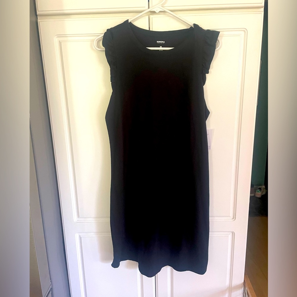 Sleeveless black dress with ruffle sleeves